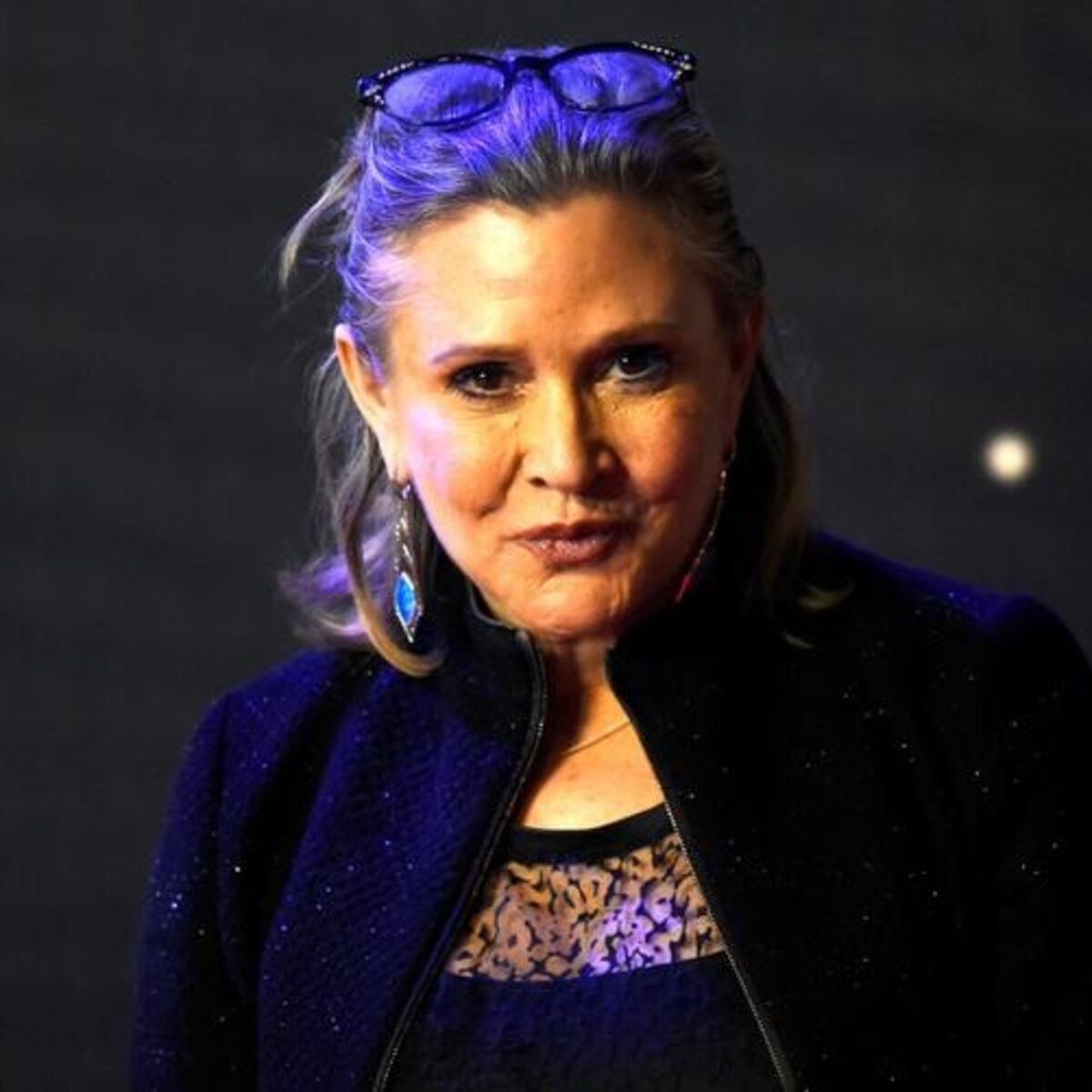 Carrie Fisher smiling in a 1980s promotional photo, a time when she struggled with addiction — Heapio