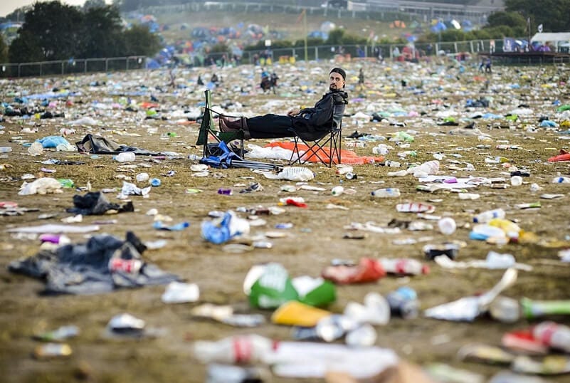Volunteers cleaning up trash after a festival, picking up plastic and debris — Heapio